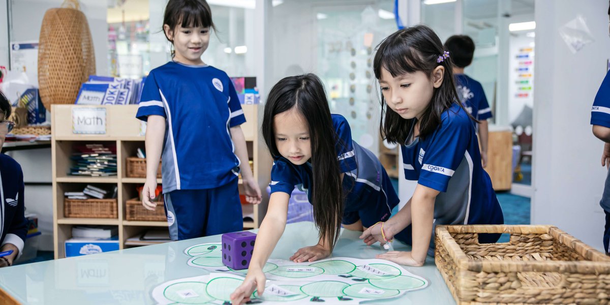 Three students standing around a table learning